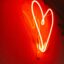 Photo of a red, glowing, neon heart against a wall. Photo by Alina Rubo on Unsplash