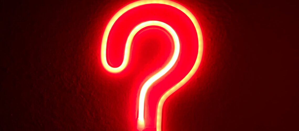Photo of a red, neon question mark against a black wall. Photo of a red, glowing, neon heart against a wall. Photo by Alina Rubo on Unsplash