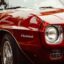 Photo of a dark red old Firebird car with black pinstripes. Photo by David Straight on Unsplash